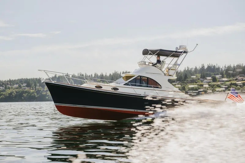 Mm Yacht Photos Pics 2010 San Juan SJ40FB IPS yacht cruising on a calm lake with scenic background.