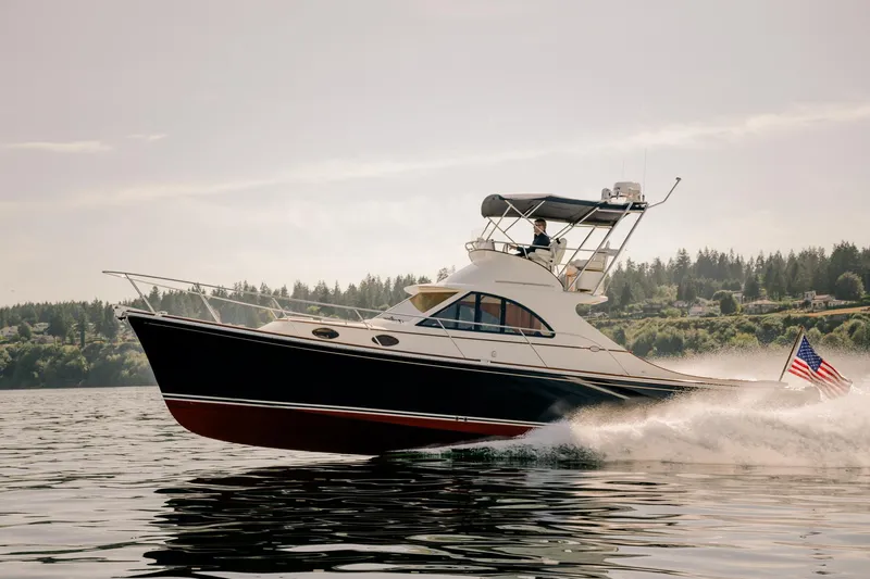 Mm Yacht Photos Pics San Juan SJ40FB IPS 2010 yacht cruising on a serene lake with American flag.