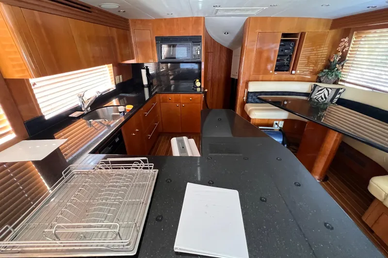 Renegade Yacht Photos Pics Luxurious kitchen interior of 2001 Hatteras 65 Convertible yacht with wood and black accents.