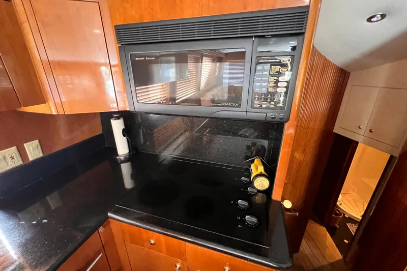 Renegade Yacht Photos Pics Kitchen area of 2001 Hatteras 65 Convertible yacht with stove and microwave.