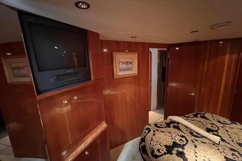 Renegade Yacht Photos Pics Luxurious interior of 2001 Hatteras 65 Convertible yacht with wood paneling and vintage TV.