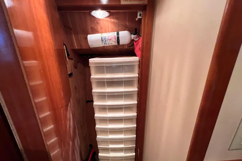 Renegade Yacht Photos Pics Storage area in 2001 Hatteras 65 Convertible with fire extinguisher and plastic drawers.