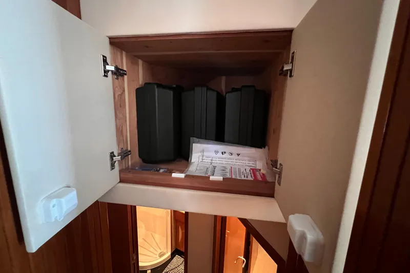 Renegade Yacht Photos Pics Storage cabinet on 2001 Hatteras 65 Convertible yacht, containing black cases and documents.