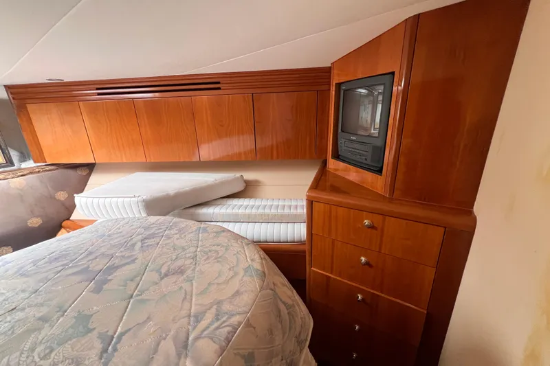 Renegade Yacht Photos Pics Luxurious cabin interior of 2001 Hatteras 65 Convertible yacht with wood cabinetry and TV.