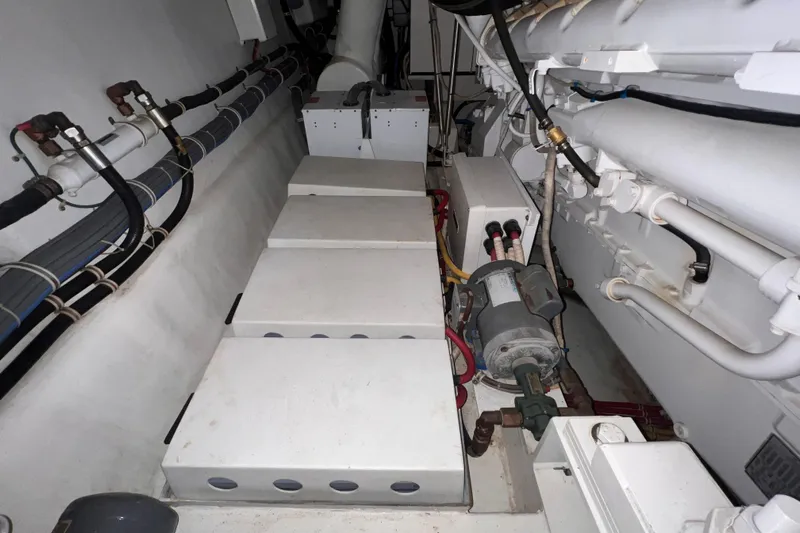 Renegade Yacht Photos Pics Engine room of a 2001 Hatteras 65 Convertible yacht, showcasing mechanical components and piping.
