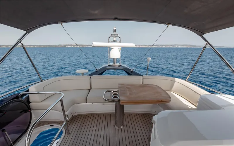  Yacht Photos Pics Luxurious 2023 Princess 45 yacht deck with seating, table, and ocean view.