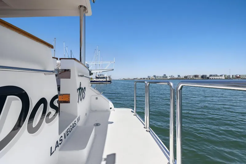 Ds Gatos Yacht Photos Pics Side view of a 1999 Symbol 558 yacht docked in a marina with cityscape background.