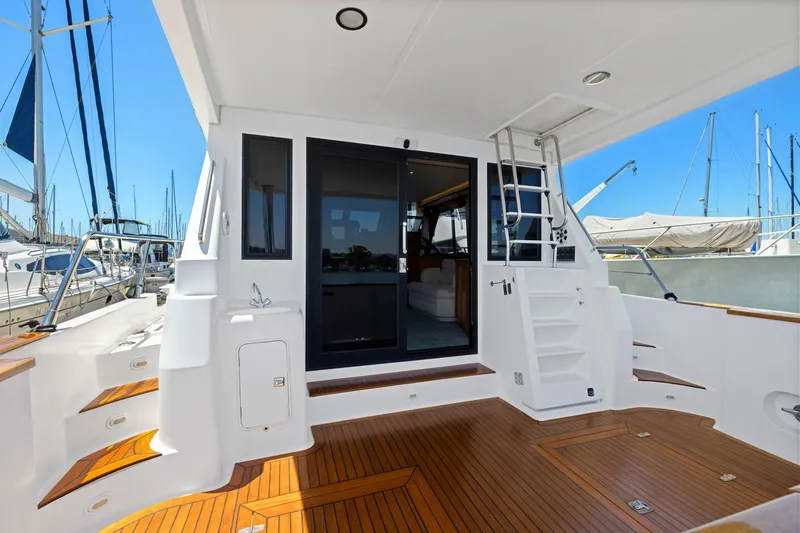 Ds Gatos Yacht Photos Pics Luxury yacht deck with wooden flooring, featuring stairs and a sliding glass door, Symbol 558, 1999.