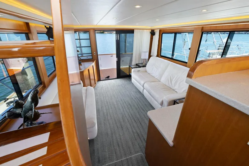 Ds Gatos Yacht Photos Pics Luxurious 1999 Symbol 558 yacht interior with white sofa, large windows, and elegant wood finishes.