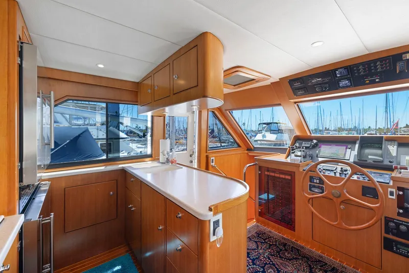 Ds Gatos Yacht Photos Pics Luxurious 1999 Symbol 558 yacht interior with wooden cabinetry and modern navigation equipment.