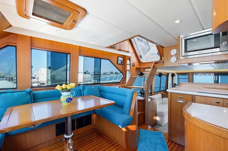 Ds Gatos Yacht Photos Pics Luxurious 1999 Symbol 558 yacht interior with wood finish, blue seating, and modern amenities.