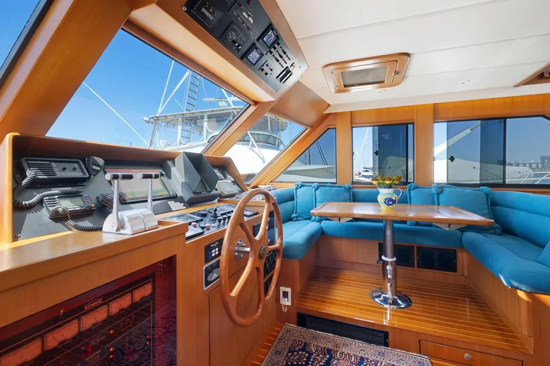 Ds Gatos Yacht Photos Pics Luxurious 1999 Symbol 558 yacht interior with wooden helm, blue seating, and dining area.