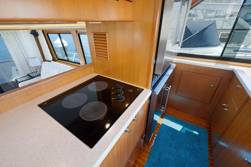 Ds Gatos Yacht Photos Pics 1999 Symbol 558 yacht kitchen with electric stove, wooden cabinetry, and ocean view.