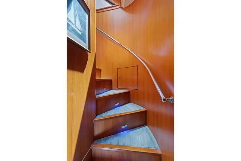 Ds Gatos Yacht Photos Pics Curved wooden staircase with blue-lit steps in a 1999 Symbol 558 yacht.