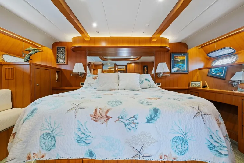 Ds Gatos Yacht Photos Pics Luxurious yacht bedroom with nautical-themed bedding, warm wood paneling, and elegant decor.