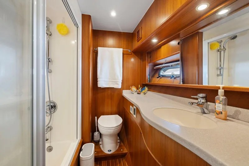 Ds Gatos Yacht Photos Pics Luxurious yacht bathroom with wooden accents, featuring a shower, toilet, and sink. Symbol 558, 1999.