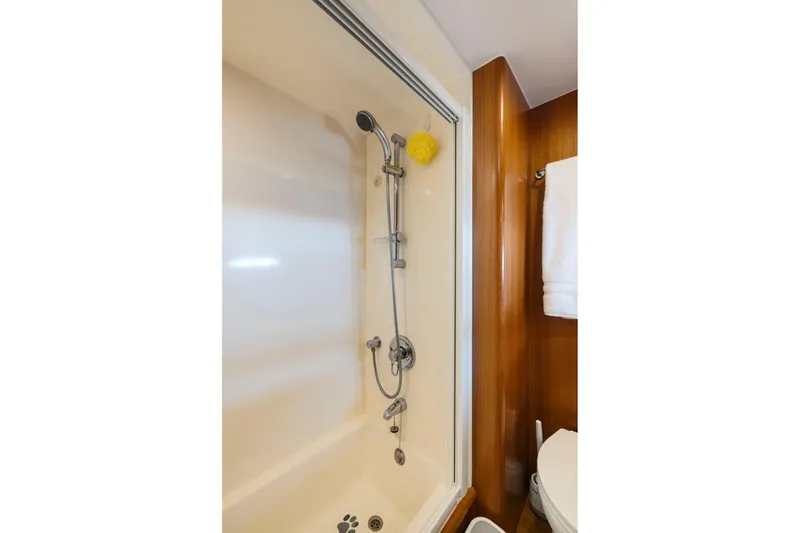 Ds Gatos Yacht Photos Pics Shower area in a 1999 Symbol 558 yacht, featuring a handheld showerhead and wooden accents.
