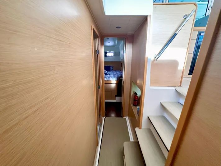 Selkie Yacht Photos Pics Interior of 2012 Lagoon 400 yacht, featuring wooden walls, stairs, and a cozy cabin.
