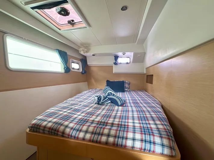 Selkie Yacht Photos Pics Cozy cabin interior of 2012 Lagoon 400 catamaran with plaid bedding and natural light.