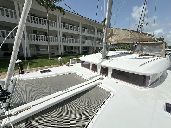 Selkie Yacht Photos Pics 2012 Lagoon 400 catamaran docked near a white building with palm trees.
