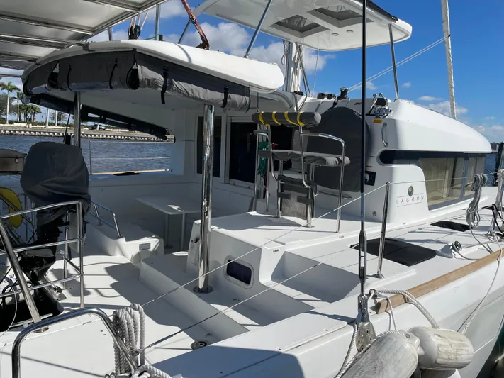 Sun Bums Yacht Photos Pics 2017 Lagoon 39 catamaran with spacious deck, docked by the water under a clear blue sky.