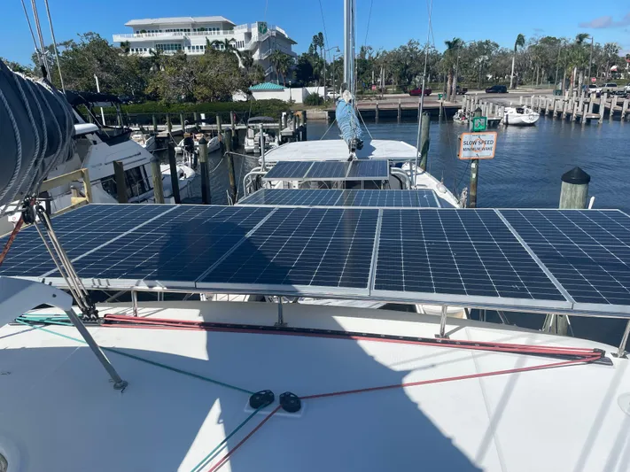 Sun Bums Yacht Photos Pics 2017 Lagoon 39 catamaran with solar panels docked at a marina.