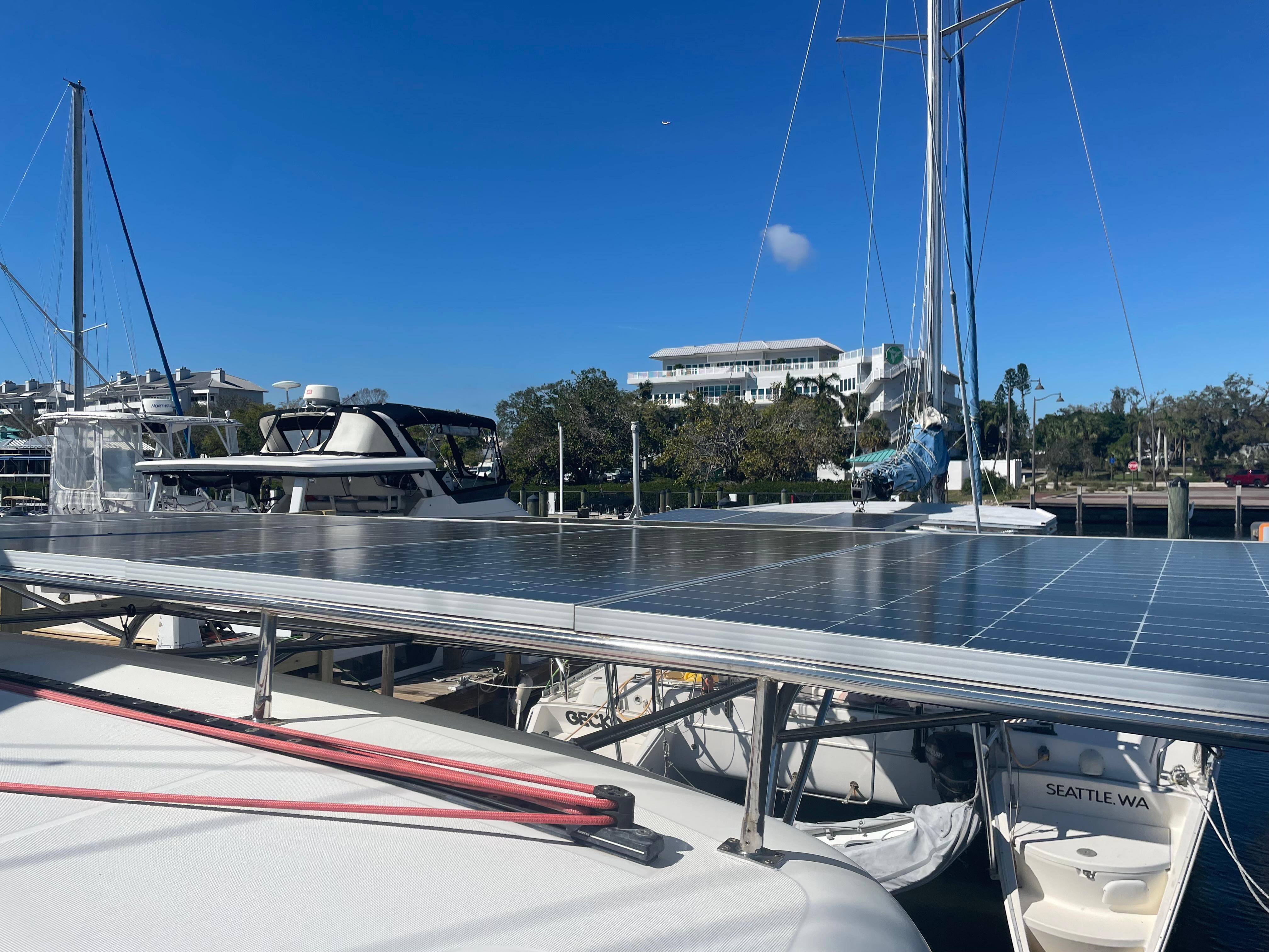 2017 Lagoon 39 catamaran with solar panels docked in a marina under clear blue skies.