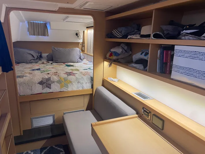 Sun Bums Yacht Photos Pics Interior of 2017 Lagoon 39 yacht cabin with bed, shelves, and seating area.