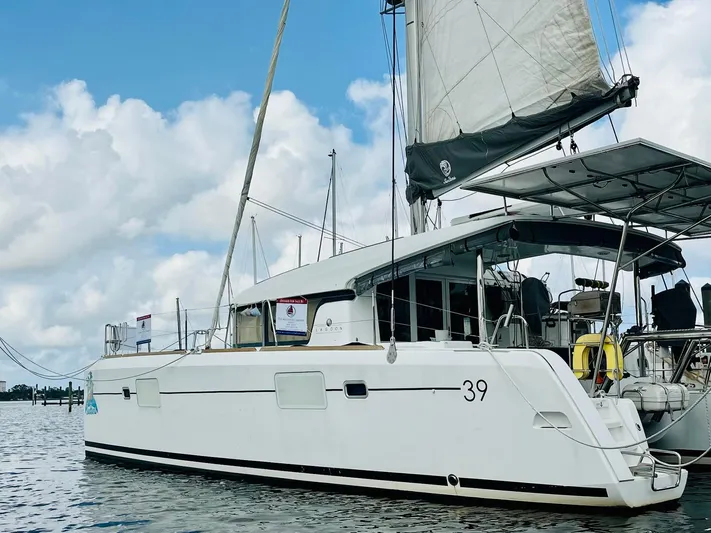 Sun Bums Yacht Photos Pics 2017 Lagoon 39 catamaran sailing on calm waters under a partly cloudy sky.