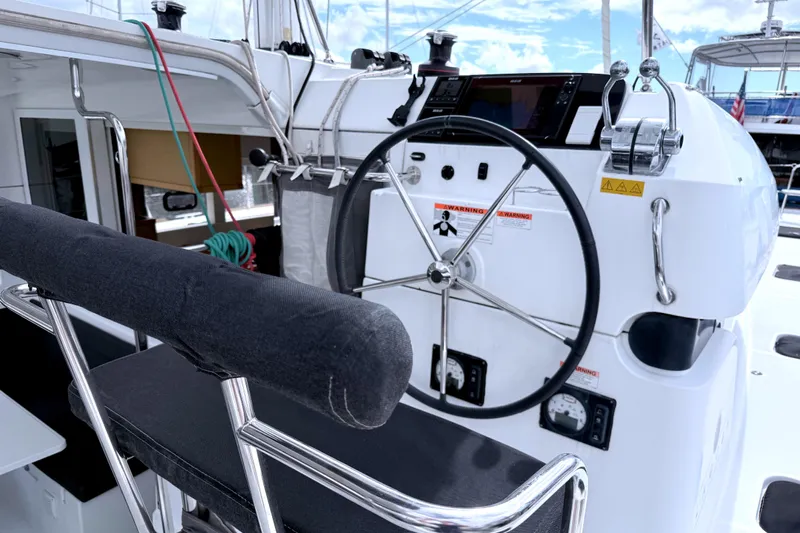 Sun Bums Yacht Photos Pics Steering wheel and controls of a 2017 Lagoon 39 catamaran, featuring modern navigation equipment.