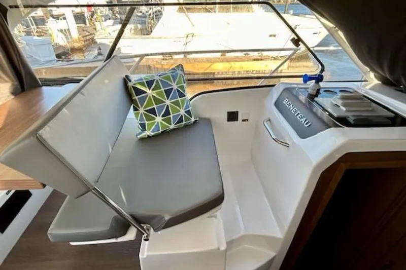  Yacht Photos Pics Interior of 2024 Beneteau Antares 9 with cushioned seating and geometric pillow.