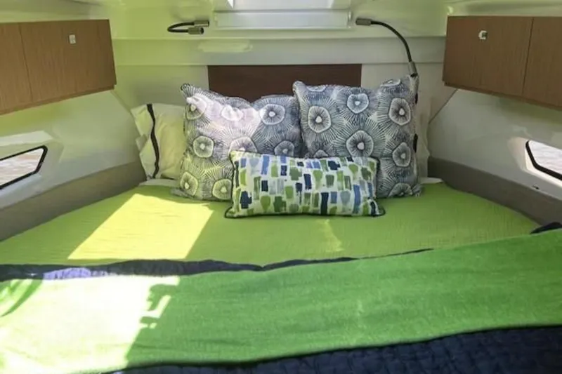  Yacht Photos Pics Cozy cabin interior of 2024 Beneteau Antares 9 with vibrant bedding and decorative pillows.