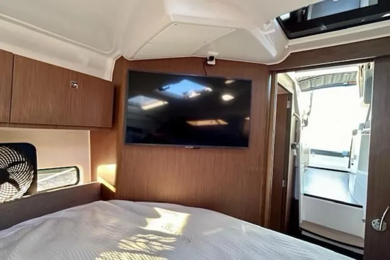  Yacht Photos Pics 2024 Beneteau Antares 9 cabin interior with TV and wooden finish.