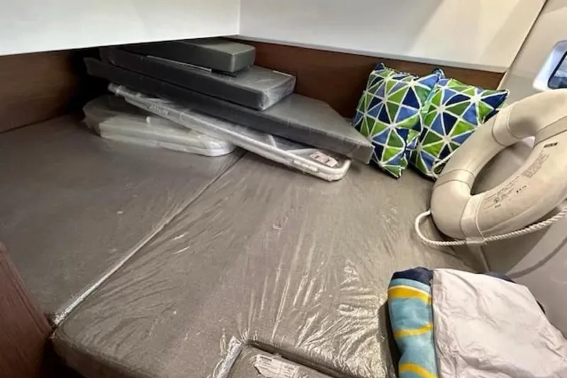  Yacht Photos Pics 2024 Beneteau Antares 9 cabin interior with cushions and life preserver.