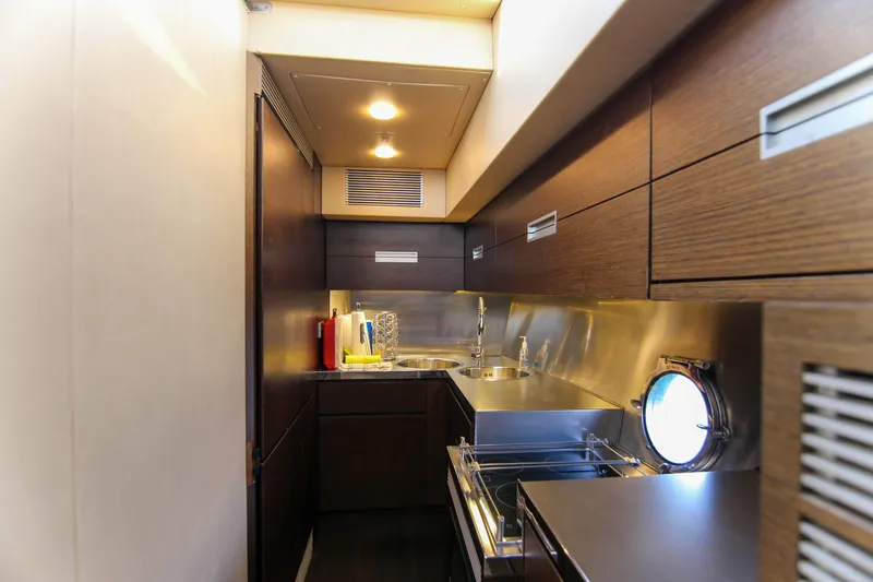  Yacht Photos Pics Luxurious kitchen interior of 2006 Azimut 68S yacht with modern wood cabinetry and stainless steel accents.
