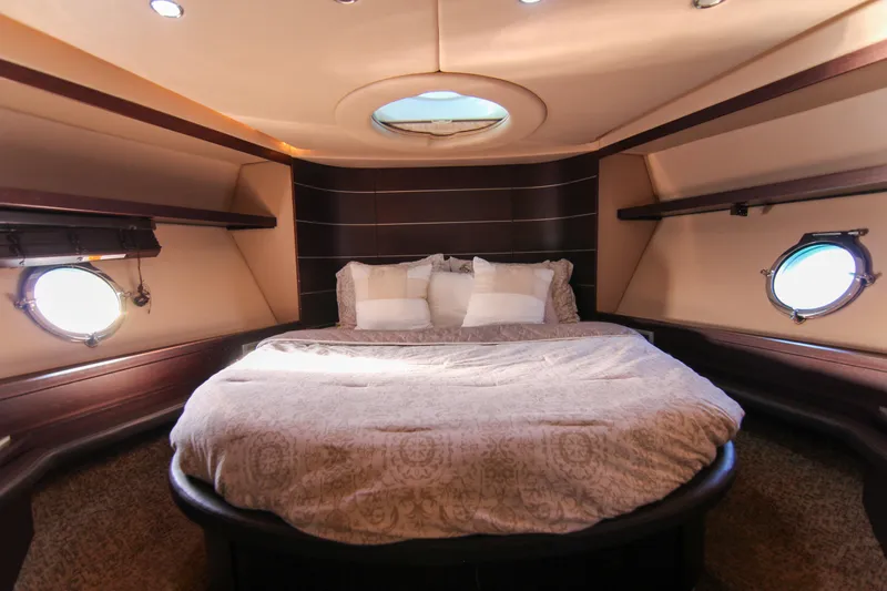  Yacht Photos Pics Luxurious bedroom interior of 2006 Azimut 68S yacht with round bed and porthole windows.