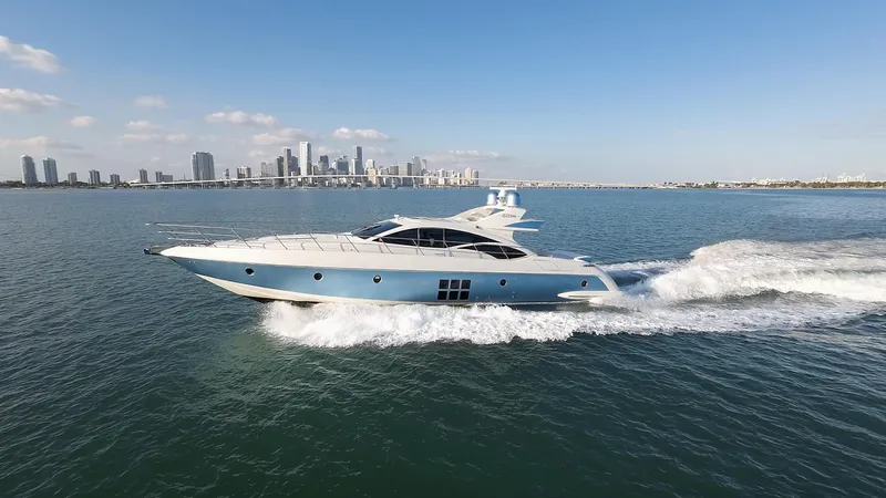  Yacht Photos Pics 2006 Azimut 68S yacht cruising on open water with city skyline in background.