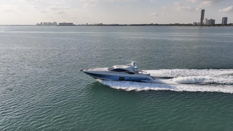  Yacht Photos Pics 2006 Azimut 68S yacht cruising on open water with city skyline in the background.