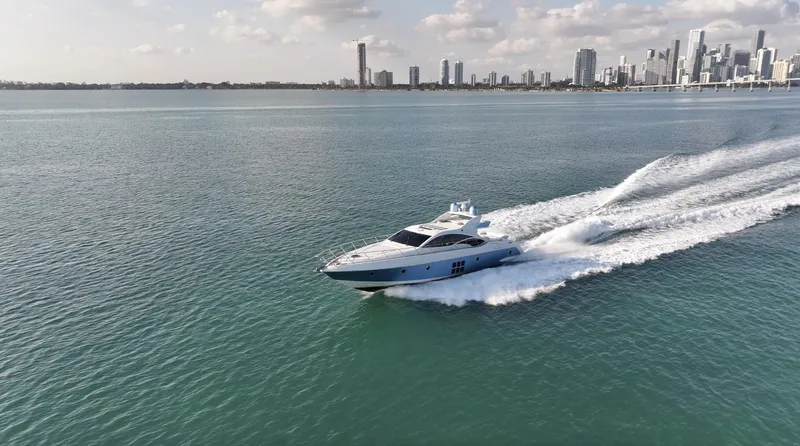  Yacht Photos Pics Azimut 68S yacht cruising on open water with city skyline in background, 2006 model.