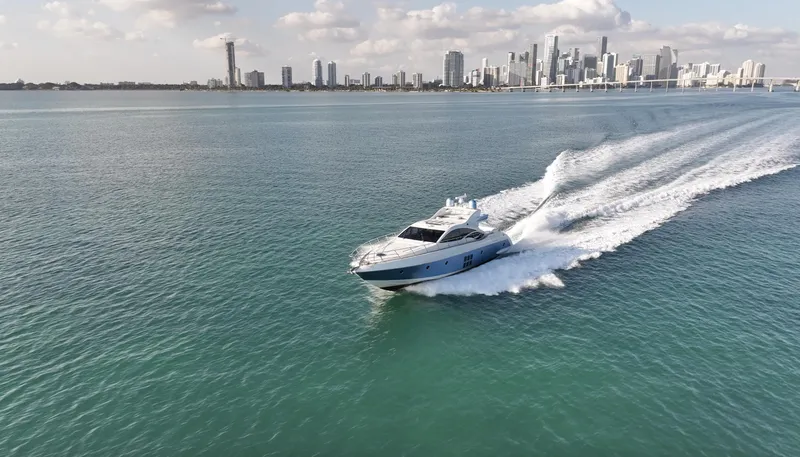  Yacht Photos Pics Azimut 68S yacht cruising near city skyline, 2006 model, on calm waters under a partly cloudy sky.