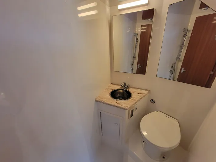  Yacht Photos Pics Compact bathroom in 2010 Jersey Cape Devil 36 boat with sink, toilet, and mirror.