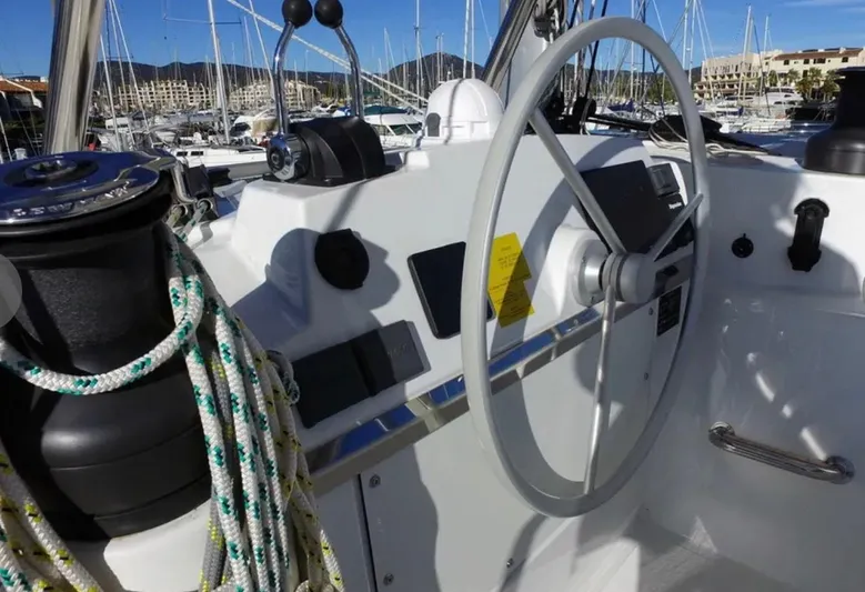  Yacht Photos Pics Steering wheel of a 2023 Bali 4.4 yacht, docked in a marina with sailboats.