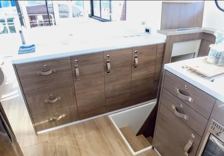  Yacht Photos Pics Modern kitchen interior in 2023 Bali 4.4 model yacht, featuring wooden cabinets and sleek countertops.