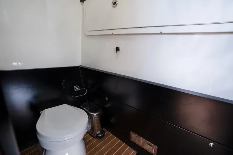  Yacht Photos Pics Modern boat bathroom interior, Skipper-BSK 42NC 2023, featuring sleek design and wooden flooring.