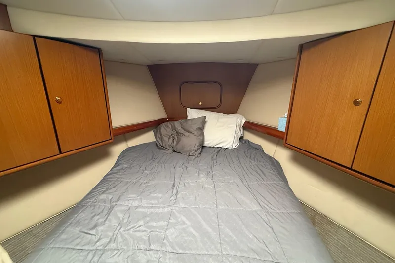 Trolling Fever Yacht Photos Pics Cozy cabin interior of 2005 Ocean Yachts 46 Super Sport with bed and wooden cabinets.