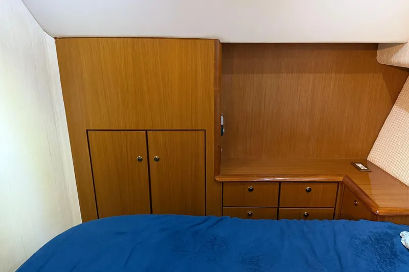 Trolling Fever Yacht Photos Pics Interior of 2005 Ocean Yachts 46 Super Sport with wooden cabinetry and blue bedding.