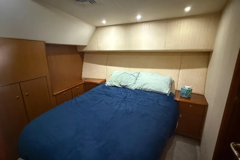 Trolling Fever Yacht Photos Pics Luxurious bedroom in 2005 Ocean Yachts 46 Super Sport with cozy bedding and wooden cabinetry.