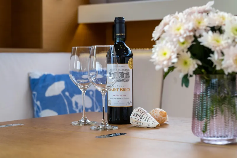 Cloudy Night Yacht Photos Pics Wine bottle and glasses on a CNB 76 yacht table with flowers and seashells.