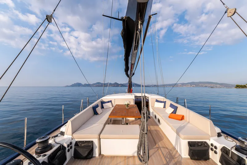 Cloudy Night Yacht Photos Pics Luxurious CNB 76 yacht deck with seating, table, and ocean view, 2019 model.