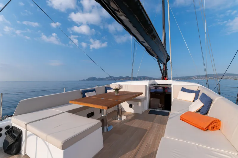 Cloudy Night Yacht Photos Pics Luxurious CNB 76 yacht deck with seating, table, and ocean view, 2019 model.